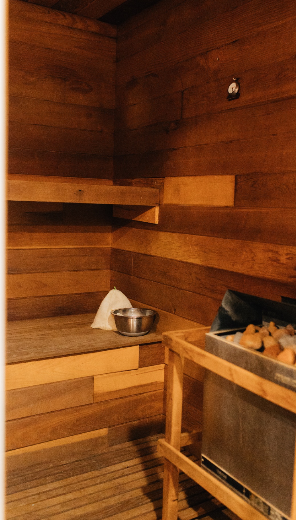 Cedar sauna with bench seating and stove