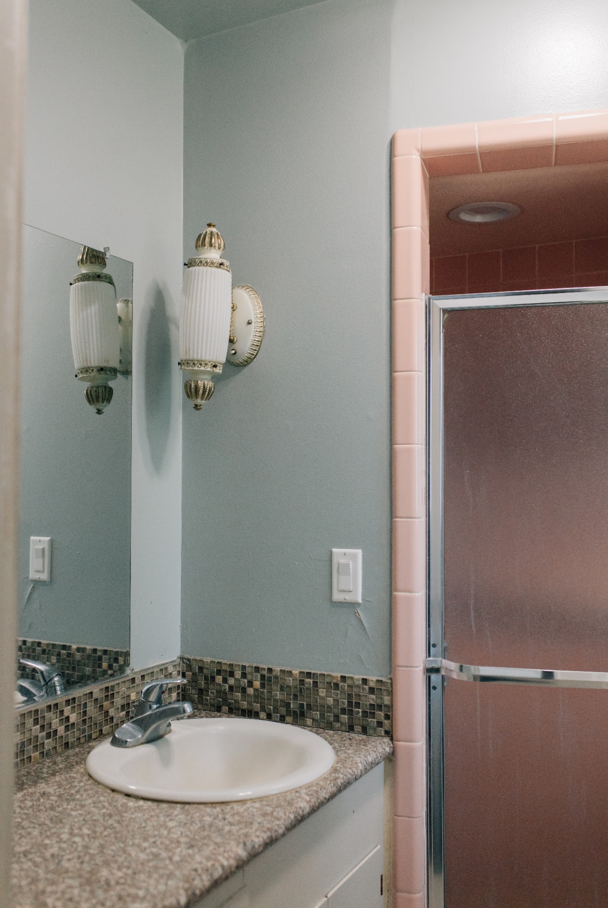 Bathroom with vintage pink tile shower and mosaic backsplash
