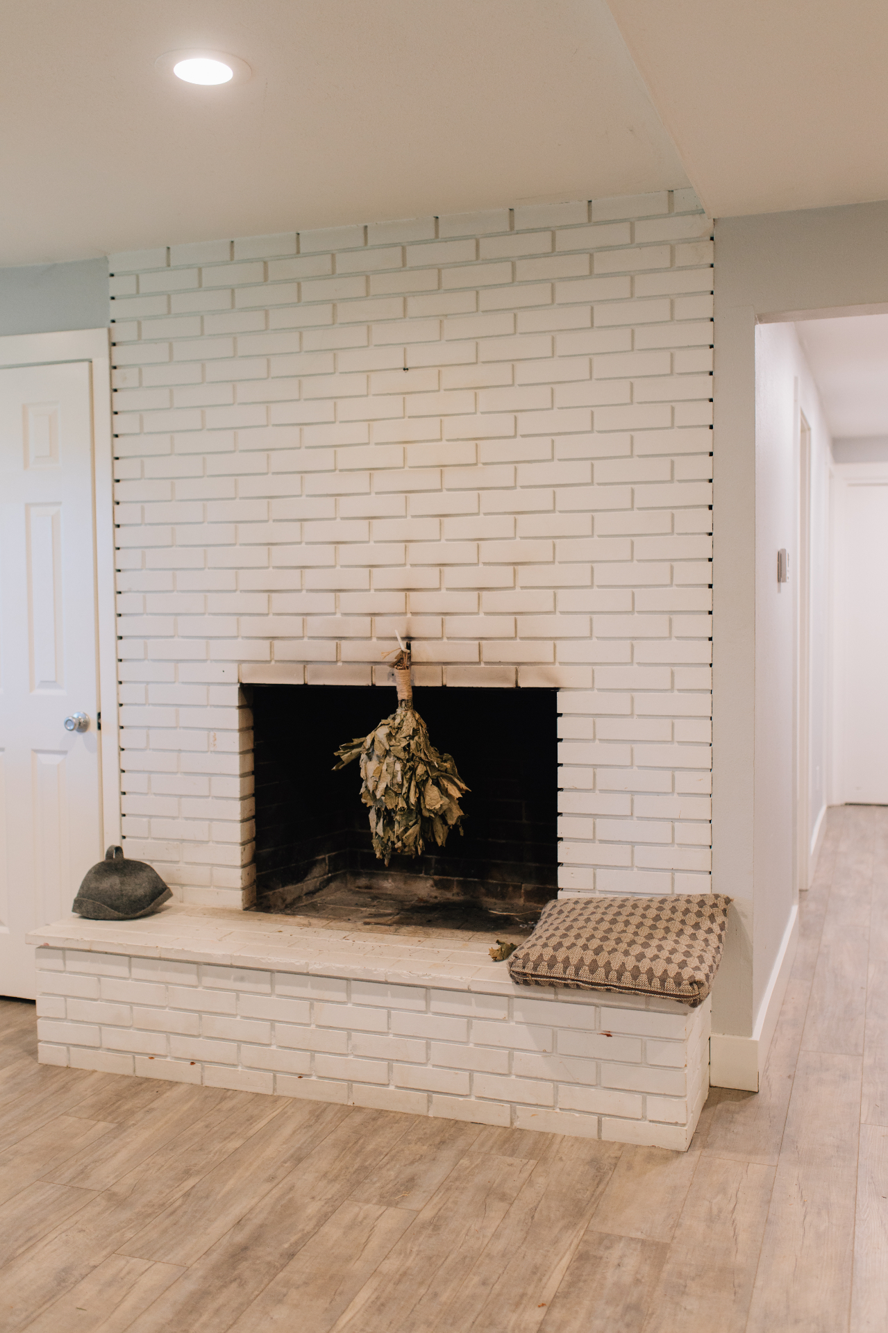 White brick fireplace with hearth bench in the sauna lounge